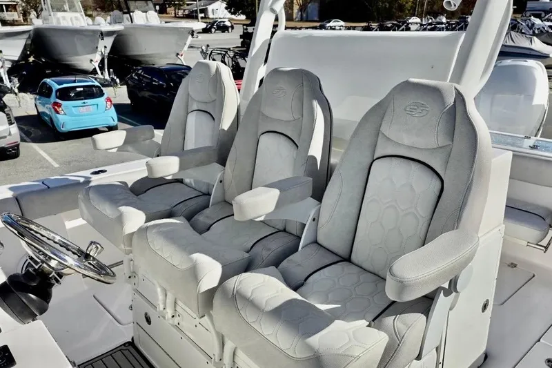 Slide: The Image of 2023 Sea Fox 328 Commander boat seats, luxurious design, gray upholstery, armrests, steering wheel visible. - 12