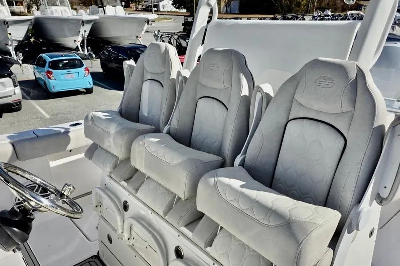 Slide: The Image of 2023 Sea Fox 328 Commander boat seats with steering wheel, parked in a marina. - 13