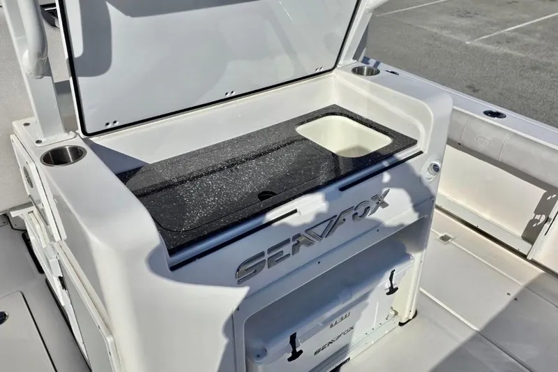 Slide: The Image of 2023 Sea Fox 328 Commander boat interior with open storage compartment and sink. - 19