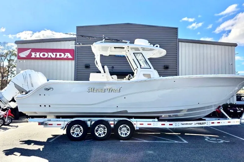 Slide: The Image of 2023 Sea Fox 328 Commander boat on trailer, parked outside Honda dealership. - 2