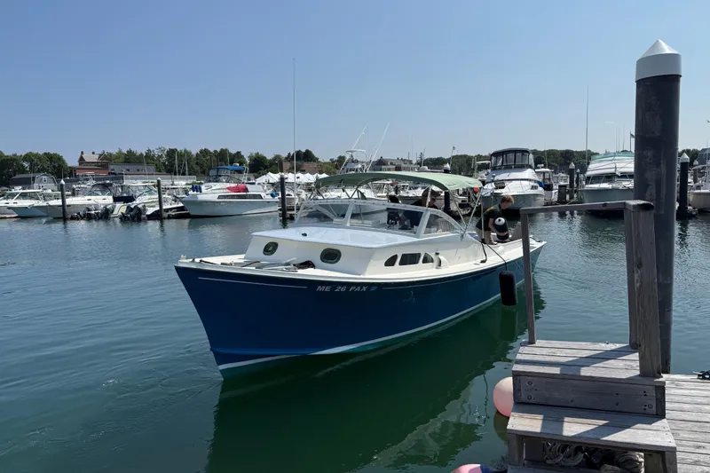 Slide: The Image of 1970 Brownell Cuttyhunk boat docked in a marina under clear skies. - 3