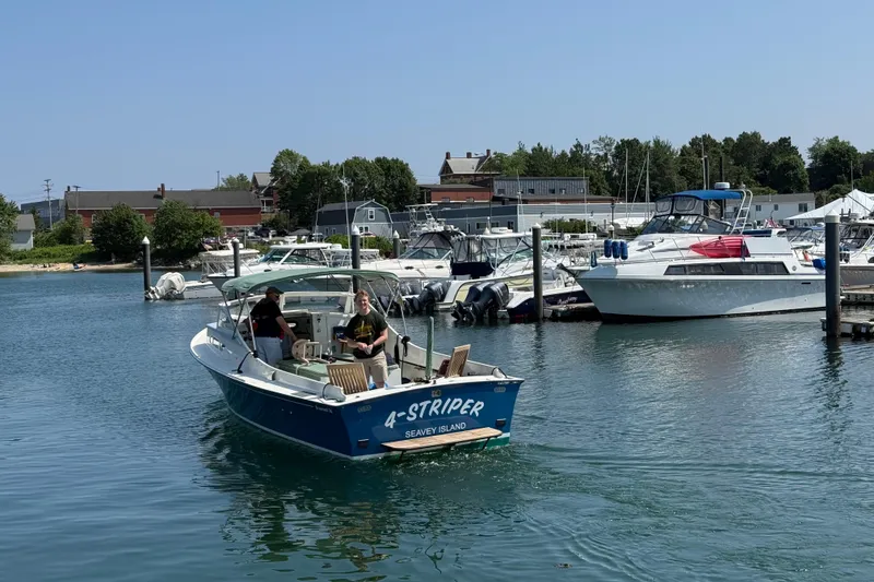 Slide: The Image of 1970 Brownell Cuttyhunk boat named "4-Striper" in a marina, sunny day. - 4