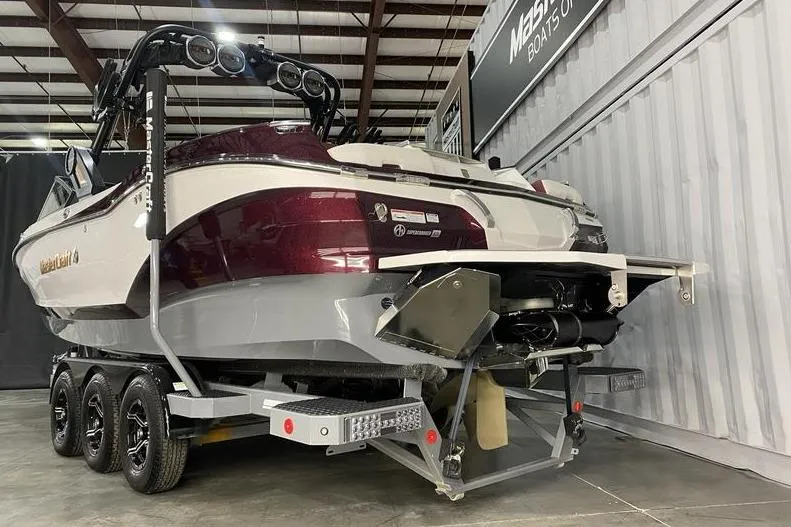 Slide: The Image of 2023 MasterCraft X26 boat on trailer in showroom, rear view. - 3