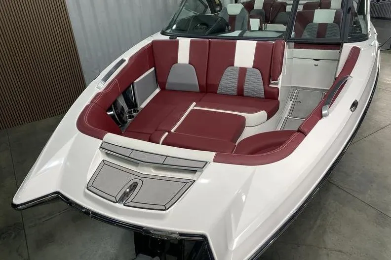 Slide: The Image of 2023 MasterCraft X26 boat with red and white seating in a showroom. - 5