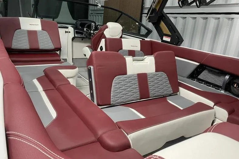 Slide: The Image of 2023 MasterCraft X26 interior with red and gray seating, modern design. - 7