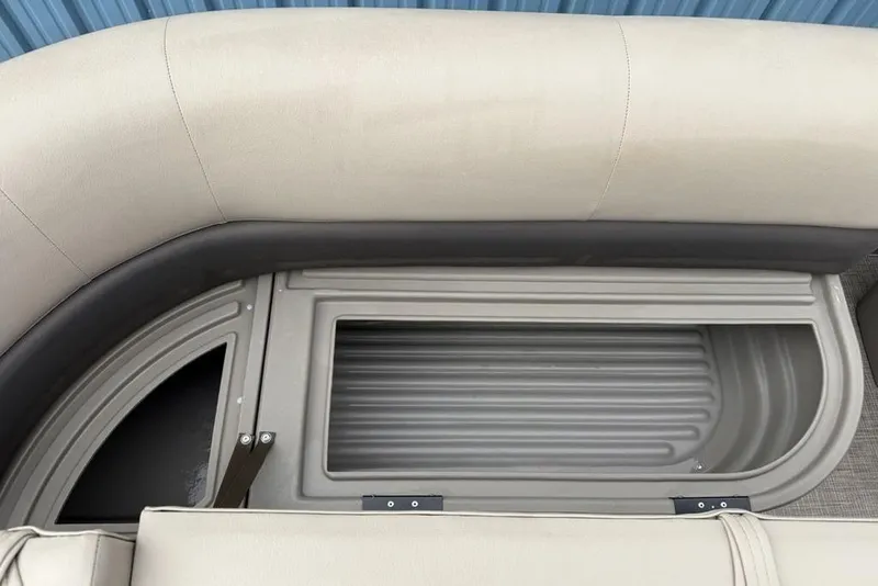 Slide: The Image of 2024 Sun Tracker Party Barge 16 DLX storage compartment with cushioned seating. - 13