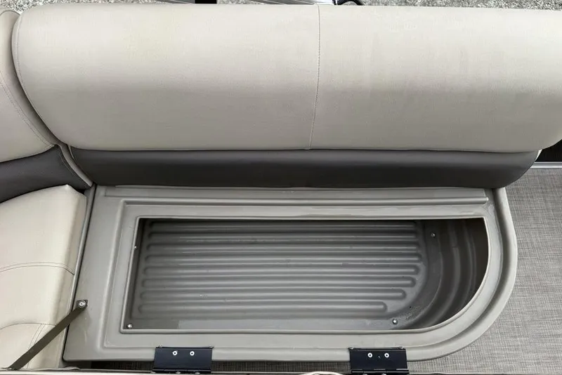 Slide: The Image of 2024 Sun Tracker Party Barge 16 DLX storage compartment with cushioned seating. - 16