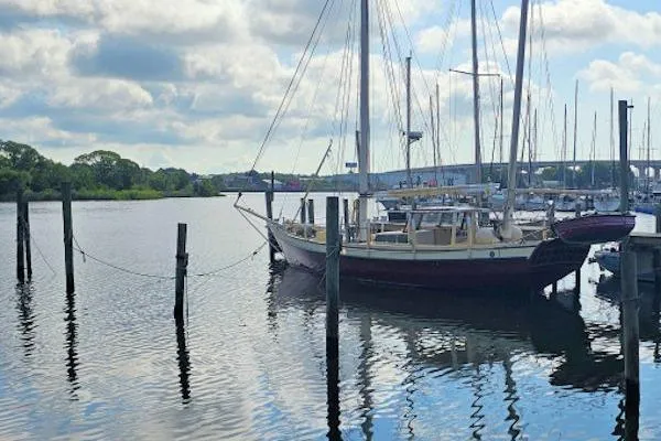 Slide: The Image of Sailboat docked at marina, Parker Marine Enterprises Lorcha 50, 2002 model, calm water, cloudy sky. - 16