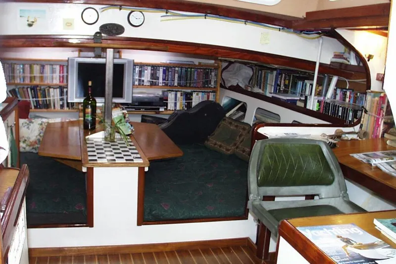 Slide: The Image of Interior of 2002 Parker Marine Lorcha 50 yacht with bookshelves and seating area. - 5