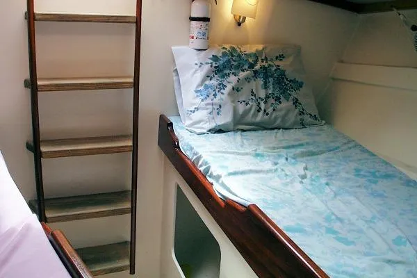Slide: The Image of Cozy cabin interior of 2002 Parker Marine Lorcha 50 with wooden ladder and floral bedding. - 9