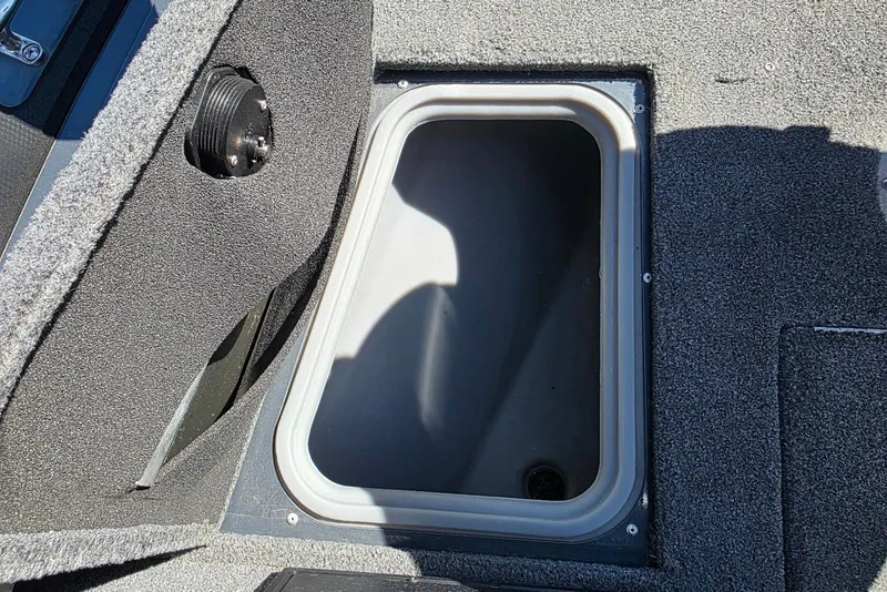 Slide: The Image of 2019 Tracker Targa V-18 WT boat storage compartment with carpeted interior. - 16