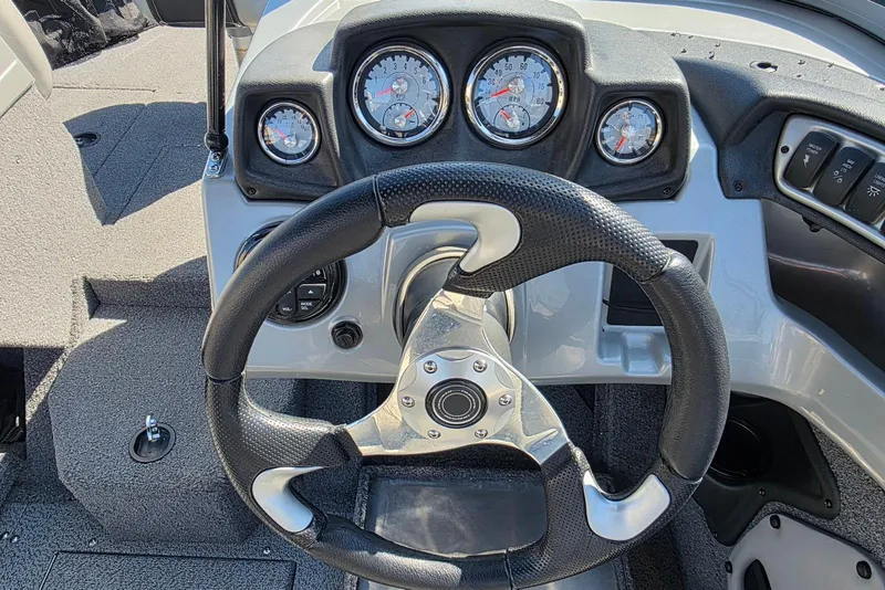 Slide: The Image of Steering wheel and dashboard of 2019 Tracker Targa V-18 WT boat, featuring gauges and controls. - 22