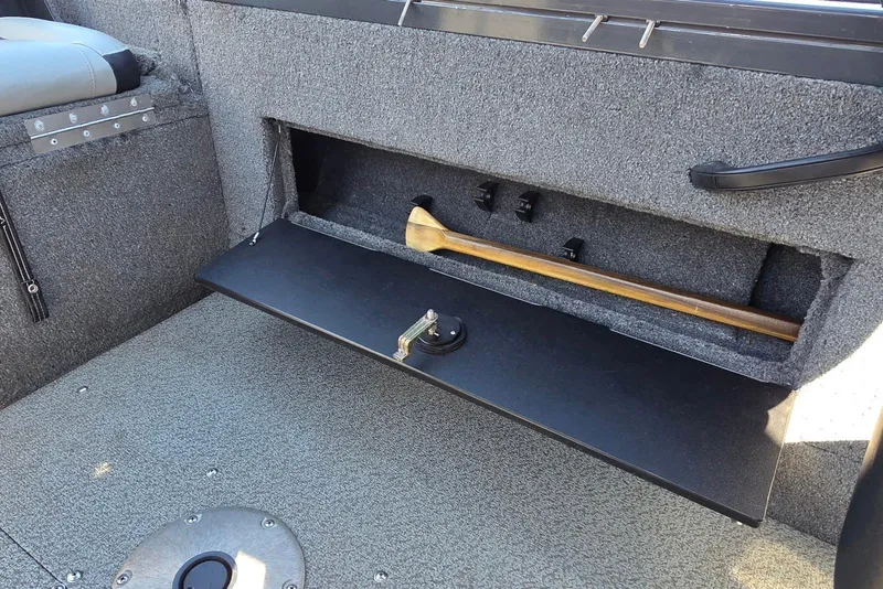 Slide: The Image of 2019 Tracker Targa V-18 WT boat storage compartment with paddle and secure latch. - 25