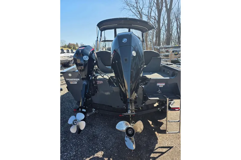 Slide: The Image of 2019 Tracker Targa V-18 WT boat with dual outboard motors, parked outdoors. - 7