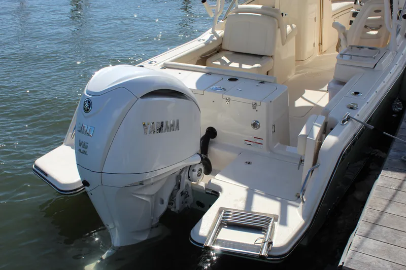 Slide: The Image of 2023 Grady-White Freedom 235 boat interior with seating and helm, docked on water. - 10