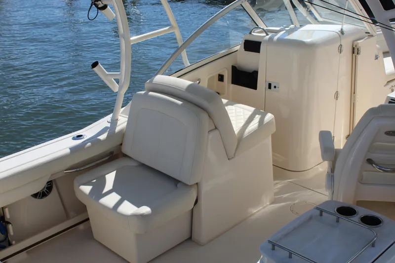 Slide: The Image of 2023 Grady-White Freedom 235 boat interior with cushioned seating at dock. - 11