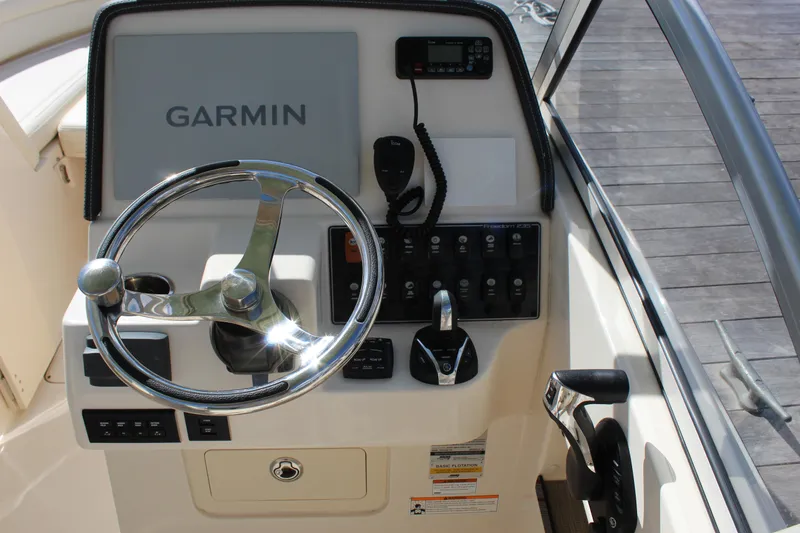 Slide: The Image of 2023 Grady-White Freedom 235 boat interior with white seating and storage compartment. - 15