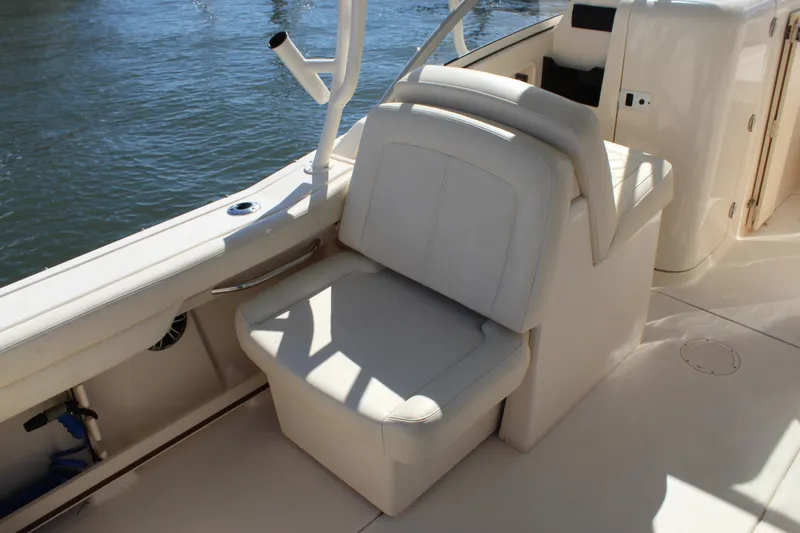 Slide: The Image of 2023 Grady-White Freedom 235 boat interior with beige seating and ocean backdrop. - 19