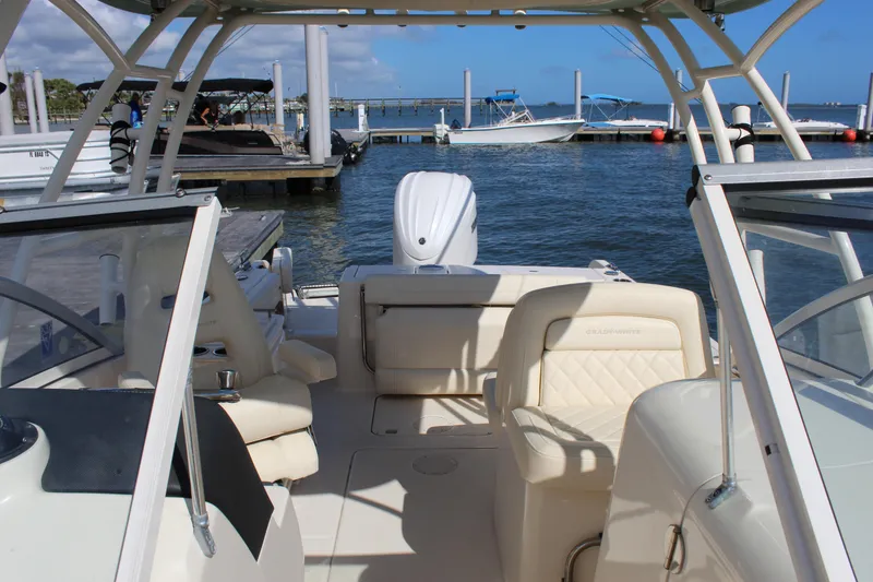 Slide: The Image of 2023 Grady-White Freedom 235 boat interior with seating, cooler, and storage compartments. - 21