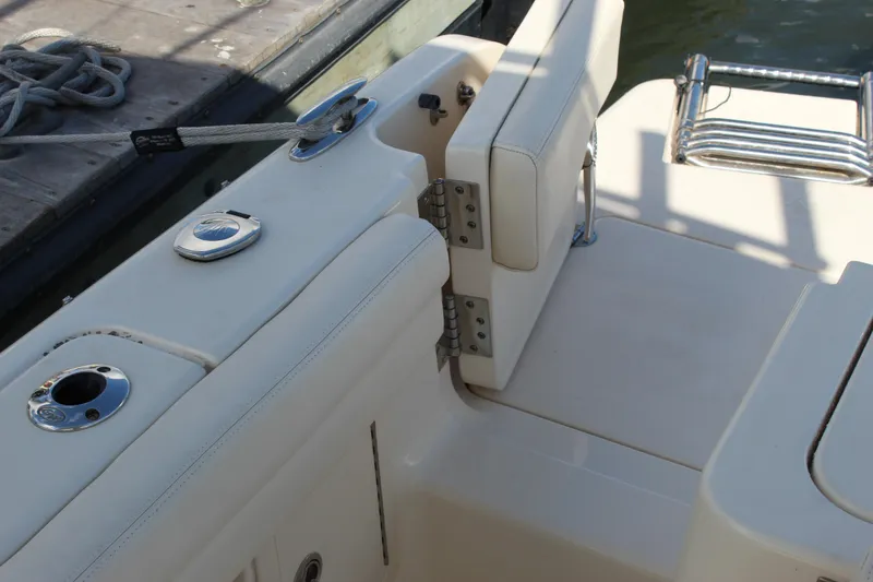 Slide: The Image of 2023 Grady-White Freedom 235 boat seating area with white upholstery and stainless steel accents. - 23