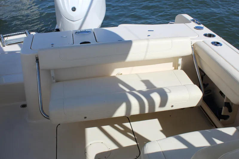 Slide: The Image of 2023 Grady-White Freedom 235 boat storage compartment with open lid and cup holders. - 24
