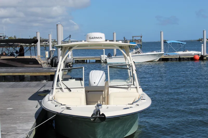 Slide: The Image of 2023 Grady-White Freedom 235 boat docked at marina, featuring Garmin equipment. - 3