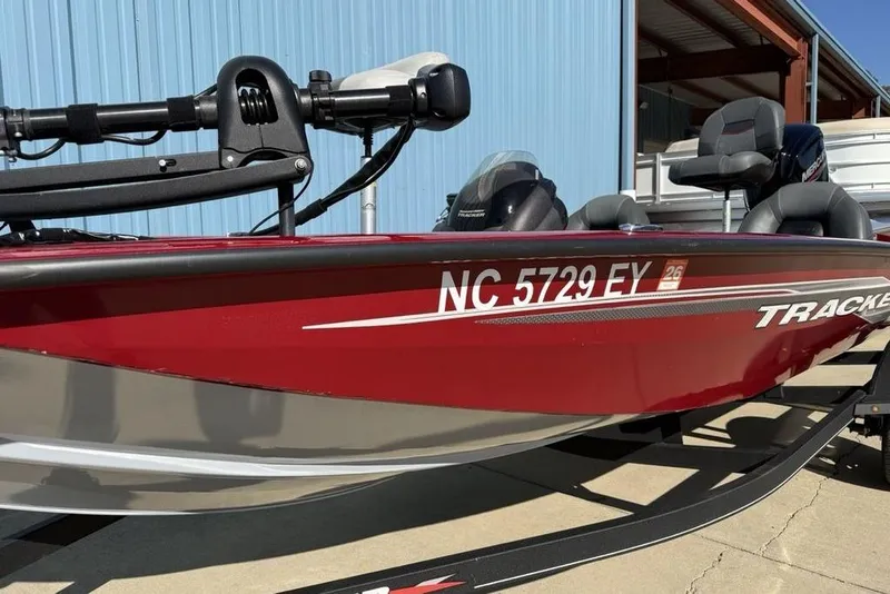 Slide: The Image of 2022 Tracker Pro Team 175 TXW Tournament Edition boat, red and silver, parked outdoors. - 3