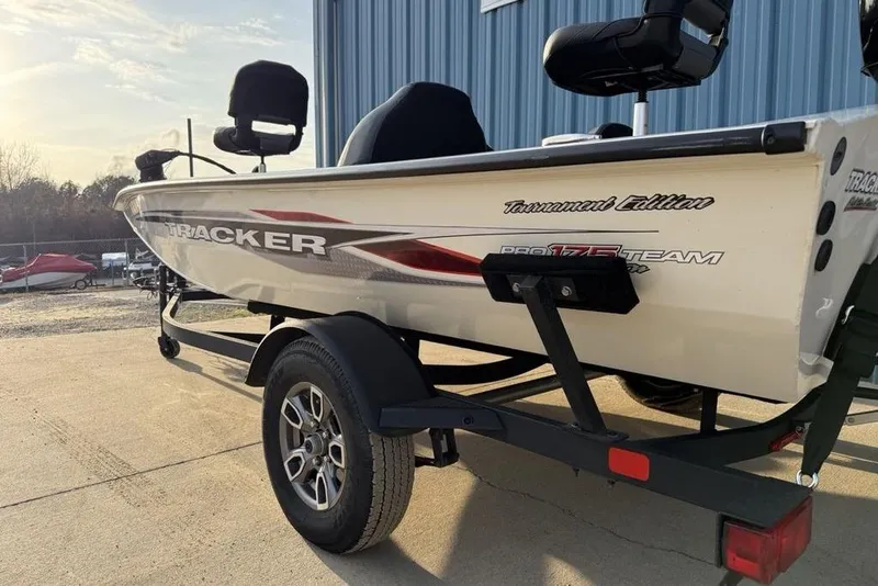 Slide: The Image of 2022 Tracker Pro Team 175 TXW boat on trailer, parked outdoors near a blue building. - 4