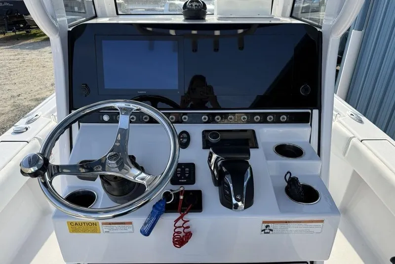 Slide: The Image of 2022 Sportsman Masters 247OE Bay Boat dashboard with steering wheel and control panel. - 16