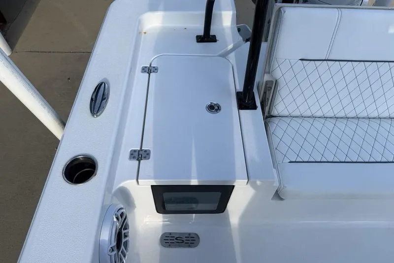 Slide: The Image of 2022 Sportsman Masters 247OE Bay Boat interior with white seating and storage compartment. - 24