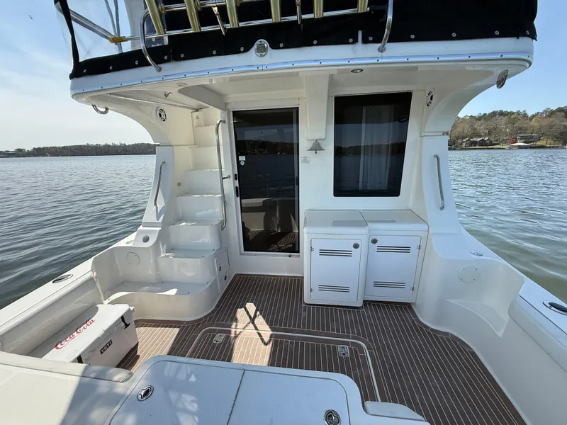 Slide: The Image of 2007 Silverton 36 Convertible yacht deck with stairs and storage, overlooking serene water. - 23