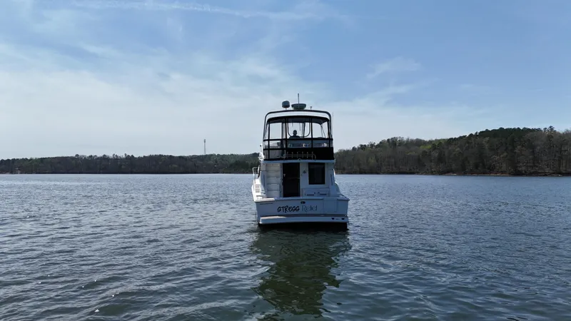Slide: The Image of 2007 Silverton 36 Convertible boat on a calm lake under a clear blue sky. - 7