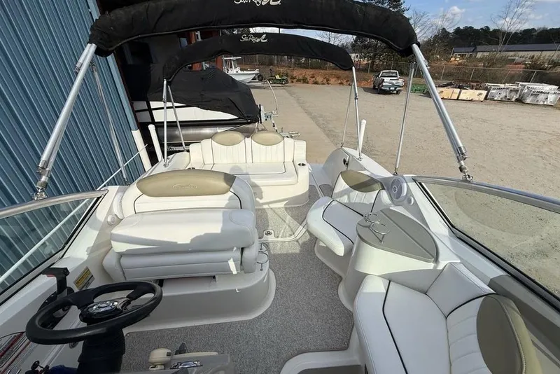Slide: The Image of 2007 Sea Ray Sundancer 540 interior with white seating and steering wheel, docked outdoors. - 39
