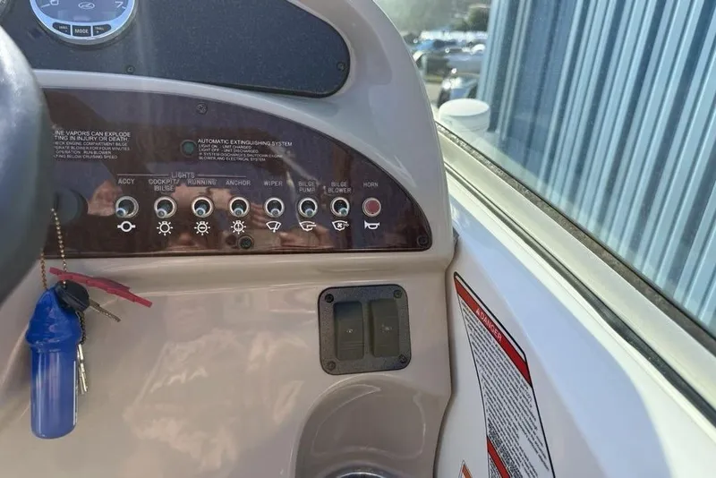 Slide: The Image of Control panel of a 2007 Sea Ray Sundancer 540 boat with various switches and keys. - 12
