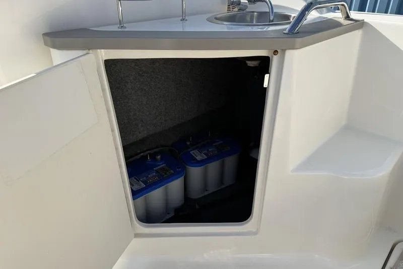 Slide: The Image of 2007 Sea Ray Sundancer 540 boat interior with open cabinet revealing batteries. - 19