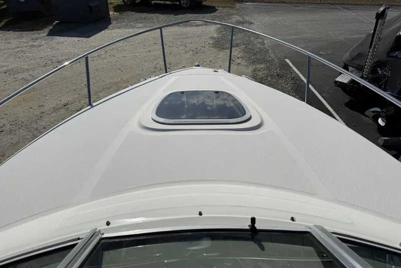 Slide: The Image of 2007 Sea Ray Sundancer 540 yacht bow with hatch, docked on gravel. - 2