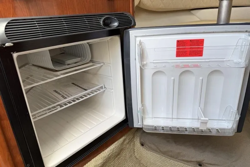 Slide: The Image of Open mini fridge inside 2007 Sea Ray Sundancer 540 yacht, showing empty shelves. - 31