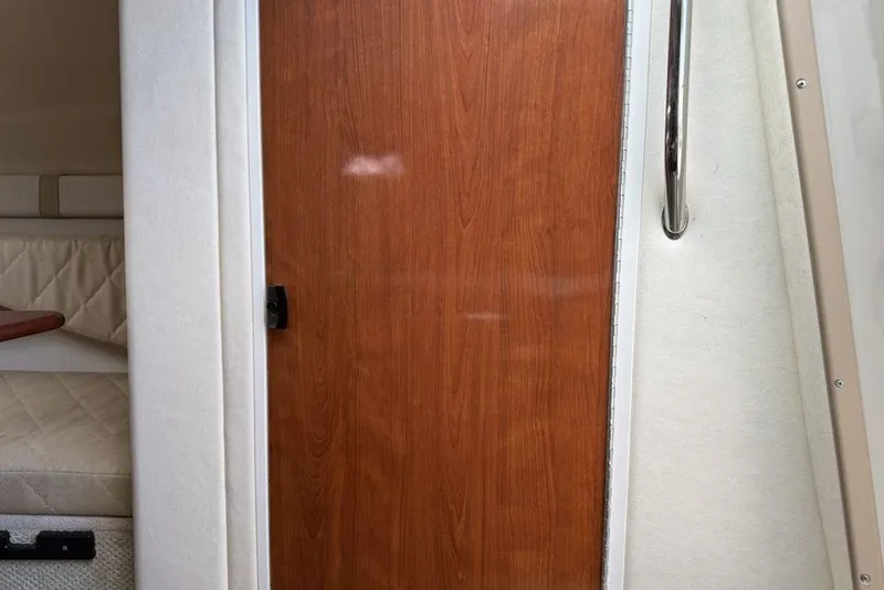 Slide: The Image of Interior cabin view of a 2007 Sea Ray Sundancer 540 yacht, featuring a wooden door and cushioned seating. - 34