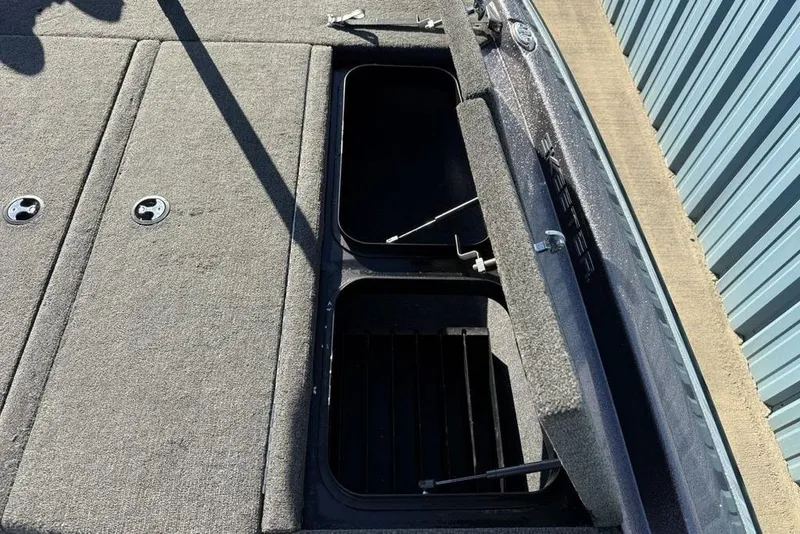 Slide: The Image of 2021 Skeeter ZXR21 boat storage compartments with open lids, showcasing interior space. - 12