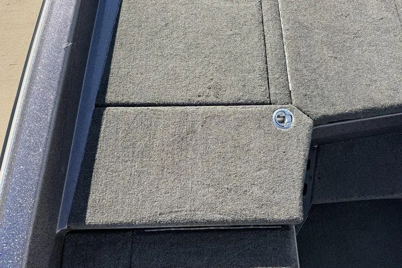 Slide: The Image of 2021 Skeeter ZXR21 boat deck with carpeted surface and storage compartment latch. - 15