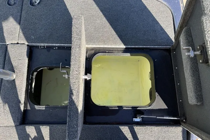 Slide: The Image of 2021 Skeeter ZXR21 boat storage compartments with open hatches, showcasing interior design. - 27