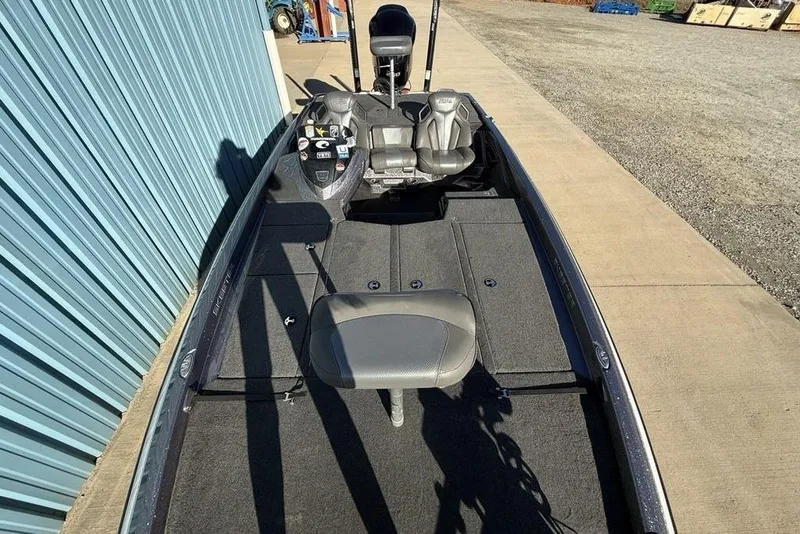 Slide: The Image of 2021 Skeeter ZXR21 fishing boat with seating and control panel, parked on concrete. - 30