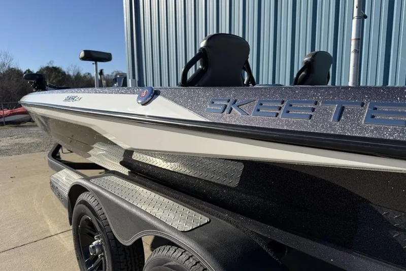 Slide: The Image of 2021 Skeeter ZXR21 boat on trailer, metallic finish, parked near blue building. - 5