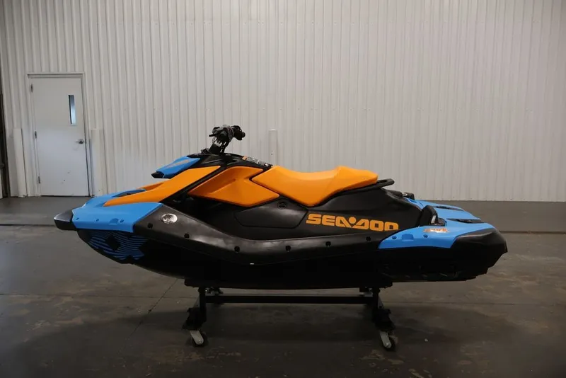 Slide: The Image of 2026 Sea-Doo Spark Trixx jet ski in vibrant blue and orange, displayed indoors. - 16