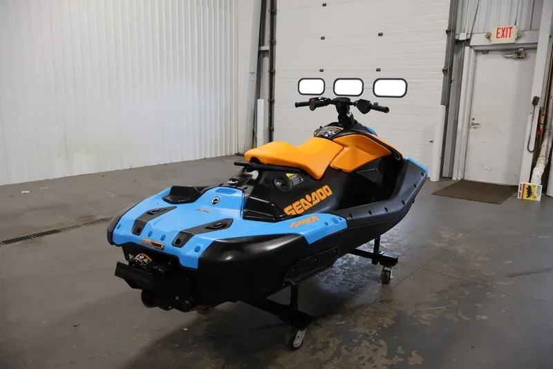 Slide: The Image of 2026 Sea-Doo Spark Trixx for 1 in a garage, featuring vibrant blue and orange design. - 5