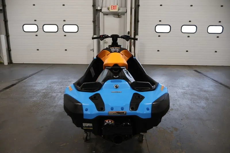 Slide: The Image of 2026 Sea-Doo Spark Trixx for 1 in a garage, showcasing vibrant blue and orange design. - 6