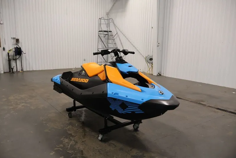 Slide: The Image of 2026 Sea-Doo Spark Trixx jet ski in a garage, featuring vibrant blue and orange design. - 4