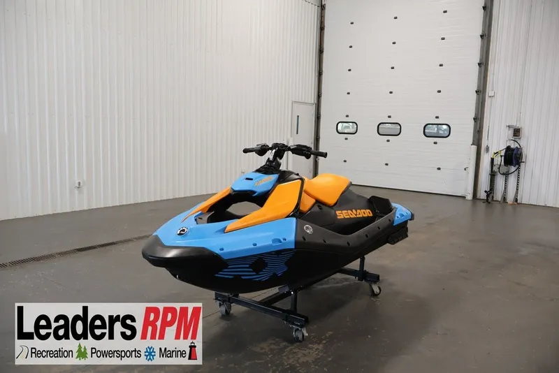 The Image of 2026 Sea-Doo Spark Trixx for 1 in a showroom, featuring vibrant orange and blue design. - 2
