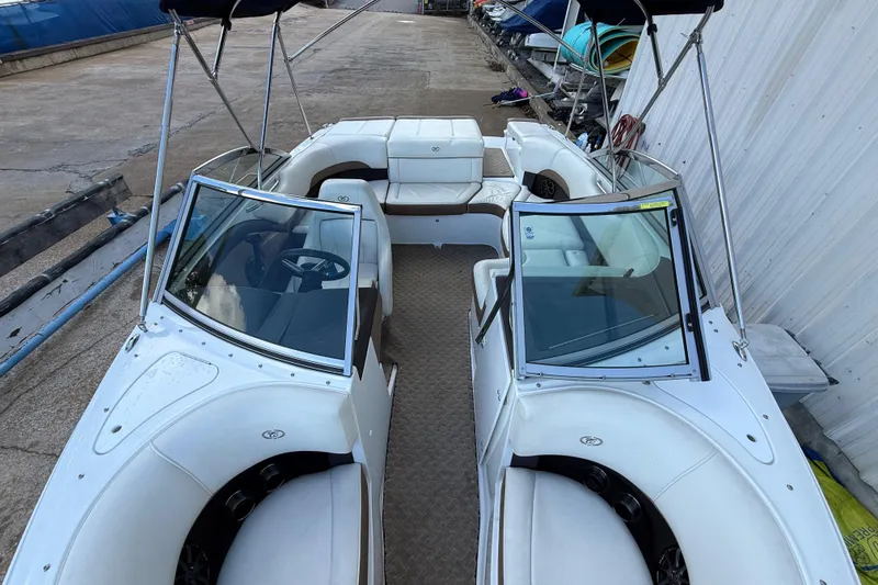 Slide: The Image of 2015 Cobalt 200 boat with white seating and dual windshields, docked outdoors. - 10