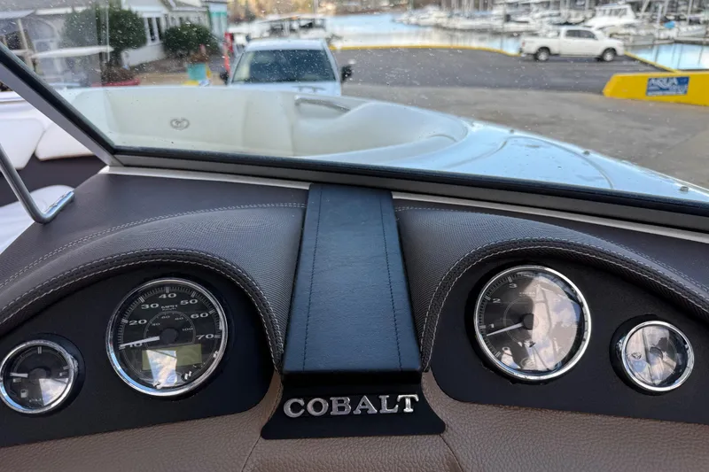 Slide: The Image of Dashboard of a 2015 Cobalt 200 boat with gauges and marina view. - 12